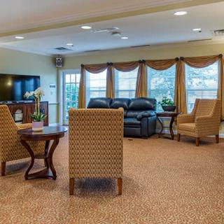 A cozy living room with comfortable seating and large windows adorned with curtains.