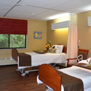 A clean and organized hospital patient room with two beds, designed for comfort and rehabilitation.