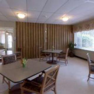 A cozy dining area with tables, chairs, and soft lighting.