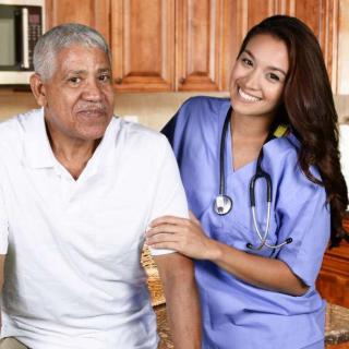 A nurse providing care and support to an elderly patient in a home setting.
