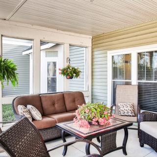 A cozy sunroom with comfortable seating and vibrant plants.