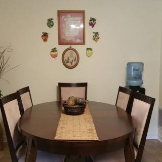 A cozy dining area with a round table, chairs, and decorative wall art.
