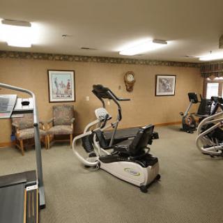 A well-equipped indoor gym featuring various exercise machines and a comfortable workout environment.