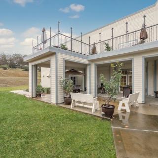 A modern house with a spacious patio and well-maintained lawn.