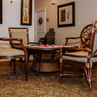 A cozy room with elegant chairs and a table, adorned with artwork on the walls.