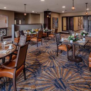 A well-appointed dining area with neatly arranged tables and chairs, featuring elegant decor and warm lighting.