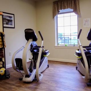 A small fitness room with recumbent exercise bikes and a window view.