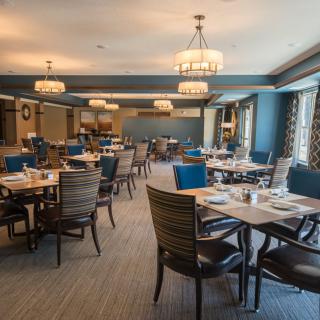 A spacious and elegantly decorated restaurant dining area with tables and chairs neatly arranged.