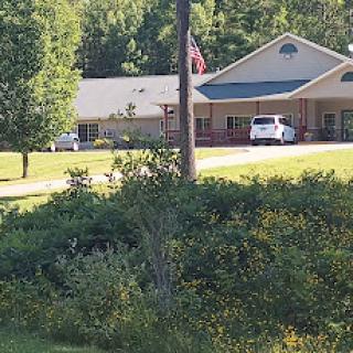 A peaceful residential building surrounded by greenery and a flag waving in the breeze.