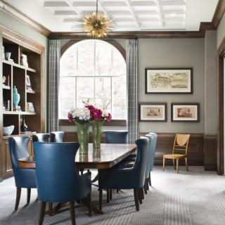 A beautifully designed dining room featuring blue chairs, a large window, and elegant decor.