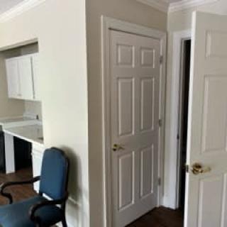 Interior view of a hallway with doors and a blue chair.