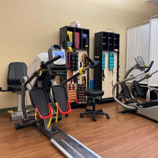 A well-equipped rehabilitation gym featuring various exercise machines and tools for fitness and therapy.
