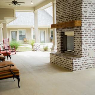 A spacious patio with a brick fireplace and comfortable seating.