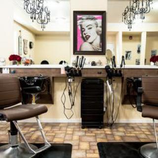 A stylish hair salon interior featuring chairs, mirrors, and chic lighting.