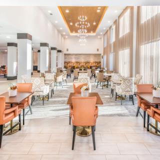 A modern dining area with stylish furniture and elegant chandeliers.