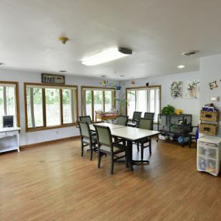 A bright and spacious dining area featuring large windows and wooden floors.