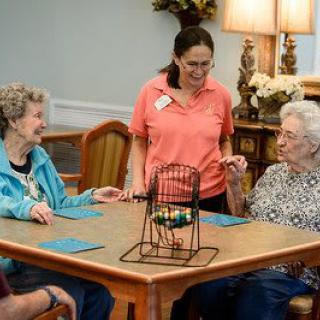 A group of elderly individuals engaging in a bingo game at a community care home.