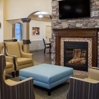 A cozy living room with armchairs and a fireplace.