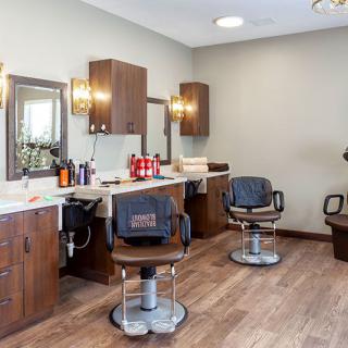 A modern barber shop interior with styling chairs and mirrors.