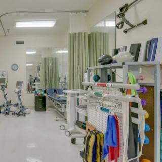 A physical therapy room with rehabilitation equipment and exercise machines.