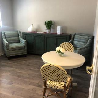A cozy living room with striped armchairs and a round table.