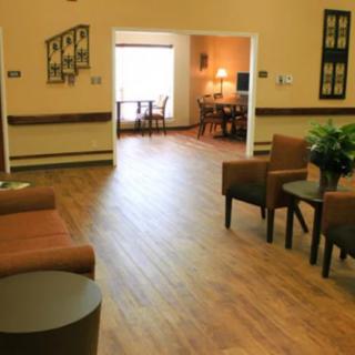 A cozy and well-lit living space with comfortable seating and wooden flooring.