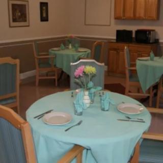 A dining room with neatly set tables and chairs, featuring a pastel color scheme.