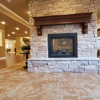 A cozy stone fireplace situated in a well-lit interior space.