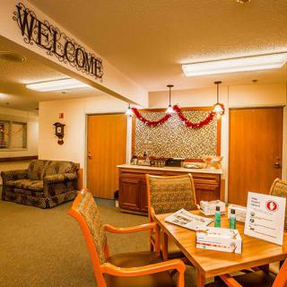 A warmly decorated lobby area with a welcome sign, featuring seating arrangements and a table with informational materials.
