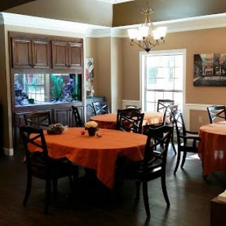 A cozy dining room set up with orange tablecloths, creating a warm and inviting atmosphere.