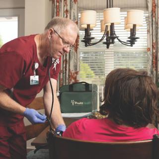 A medical professional conducts a check-up on a patient in a home setting.