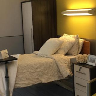 A cozy, well-lit bedroom featuring a neatly made bed and modern furniture.
