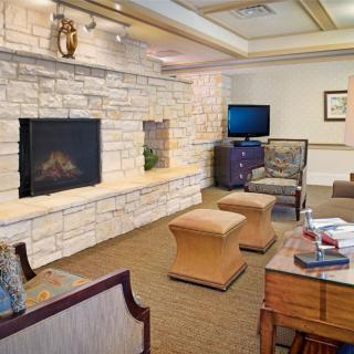A cozy living room with a stone fireplace and comfortable seating.