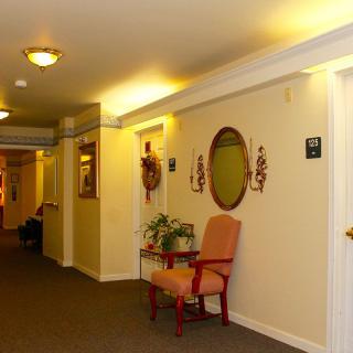 A warmly lit hallway with a chair and decorative items.