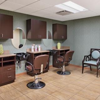 A modern salon interior featuring stylish chairs, mirrors, and storage cabinets.