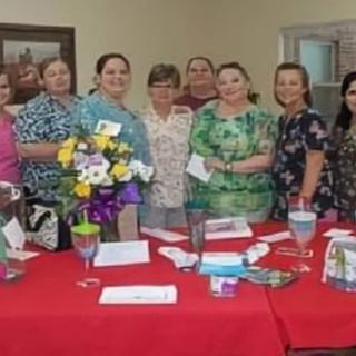 A group of people gathered around a table with flowers and decorations.