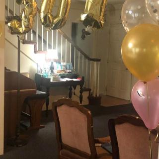 A festive interior scene with balloons and decorations.