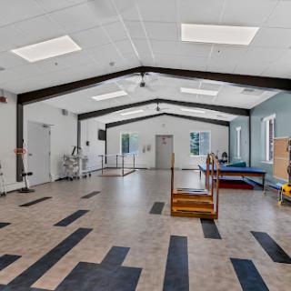 A spacious and well-equipped rehabilitation center featuring a variety of exercise equipment and an open layout for physical activities.