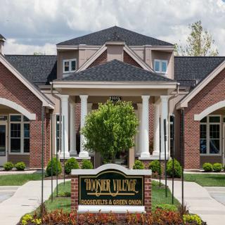 A stately brick funeral home with columns and manicured landscaping.