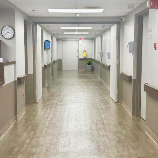 A view of an empty hospital corridor, showcasing the clean and organized environment typical of a healthcare facility.