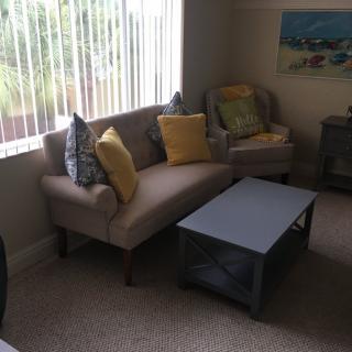 A cozy living room with a sofa, colorful cushions, and a coffee table.