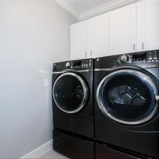 Modern laundry room with black washer and dryer.