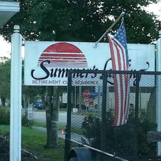 An outdoor sign for a restaurant named 'Summer's Landing' featuring an American flag.