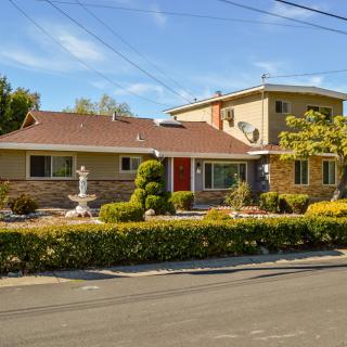 A suburban house with well-maintained landscaping and a fountain in the front yard.