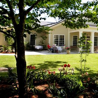 A charming house with a lush garden and patio area.