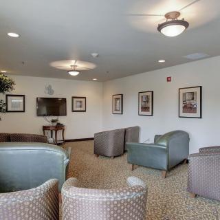 A comfortable lounge area with chairs and a television.