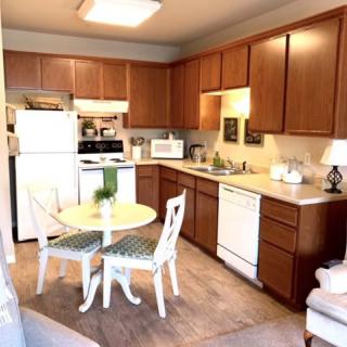 A cozy kitchen with wooden cabinets and a small dining table.
