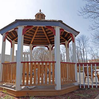 A wooden gazebo located outdoors in a park setting.