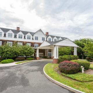 A large building with a covered entrance and manicured landscaping.
