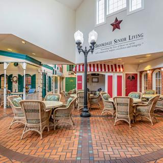 A cozy indoor seating area with wicker furniture and decorative storefronts.